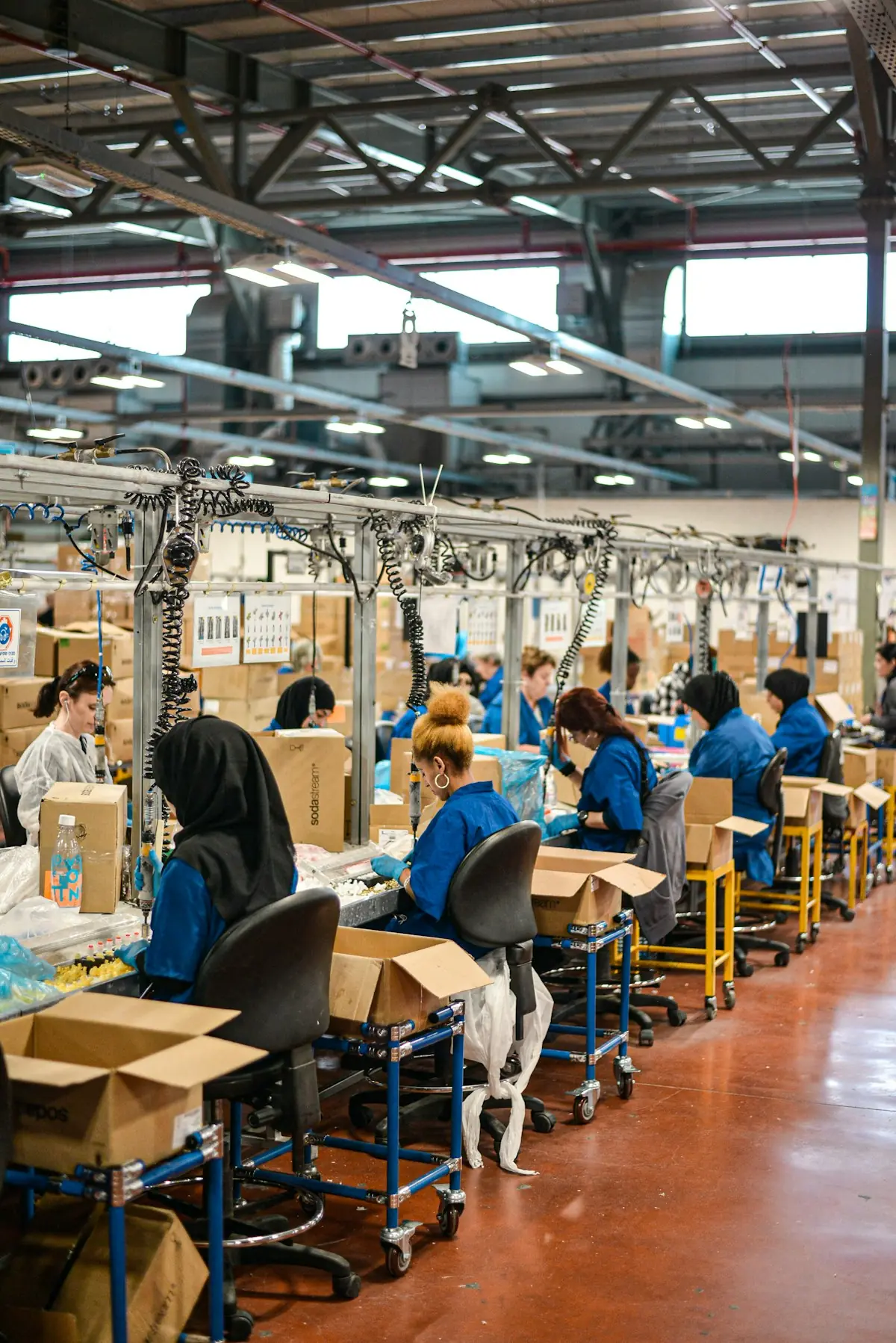 Workers at an assembly line in a large factory hall